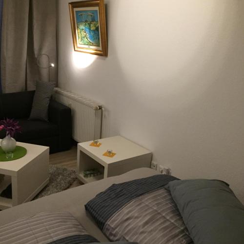 a bedroom with a bed and a couch and a table at Mini-Ferien-Suite Hildesheim in Hildesheim