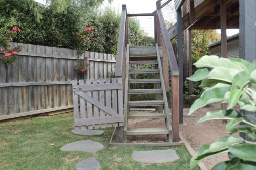 a wooden staircase leading up to a wooden fence at Tree House Jan Juc in Torquay