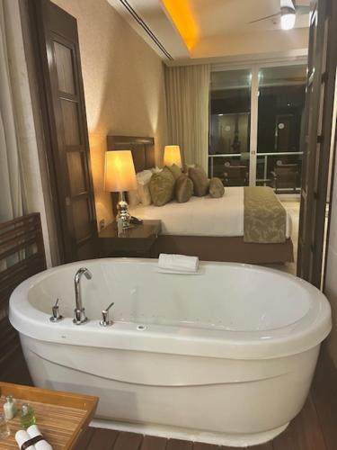 a bathroom with a bath tub and a bed at 2 Bedroom Luxury Condo in Nuevo Vallarta 