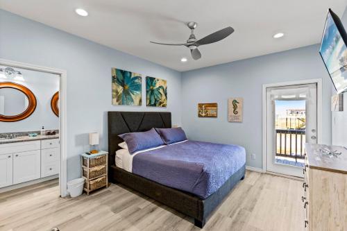 a bedroom with a bed and a ceiling fan at Beachfront HotTub Gameroom CargoLift - SandyCheeks in Bolivar Peninsula