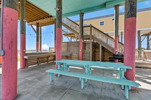 a blue bench sitting in front of a building at Beachfront HotTub Gameroom CargoLift - SandyCheeks in Bolivar Peninsula