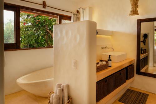 a bathroom with a tub and a sink and a bath tub at ZOA Hotel - Adults Only in Mazunte