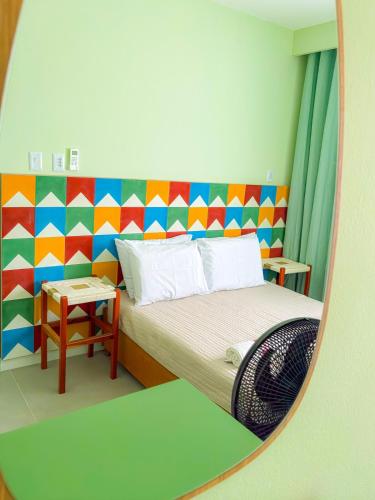 a small bedroom with a bed and a mirror at Lindo, Novo e Decorado - 202 C in Petrolina