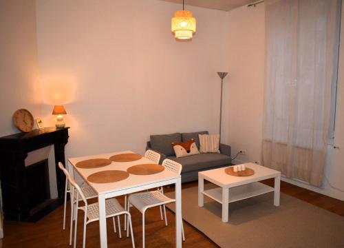 un salon avec une table et un canapé dans l'établissement Appartement à 10 min de Paris - Train, Métro, à Noisy-le-Sec