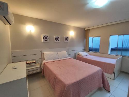 Una habitación de hotel con dos camas y una ventana. en Apartamento próximo à praia, en Lauro de Freitas