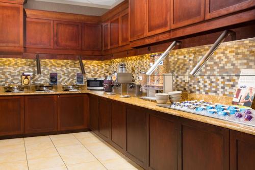 Una cocina grande con gabinetes de madera y encimera. en Residence Inn Kansas City Airport, en Kansas City
