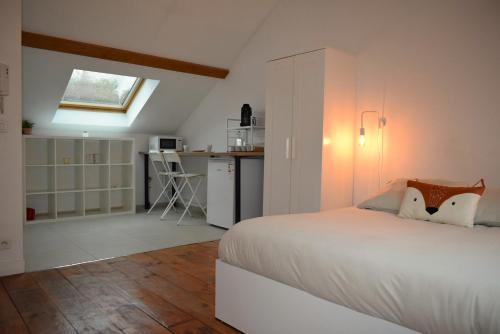 Cet appartement comprend une chambre avec un lit blanc et une cuisine. dans l'établissement Appartement à 10 min de Paris - Train, Métro, à Noisy-le-Sec