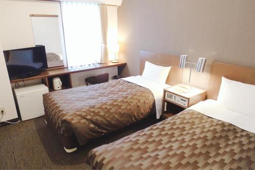 a hotel room with two beds and a television at Marroad Inn Akasaka in Tokyo