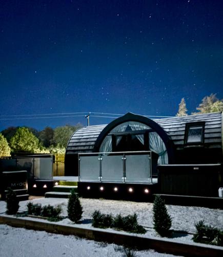 a domed building with a door in a yard at night at Mingarry Park in Acharacle