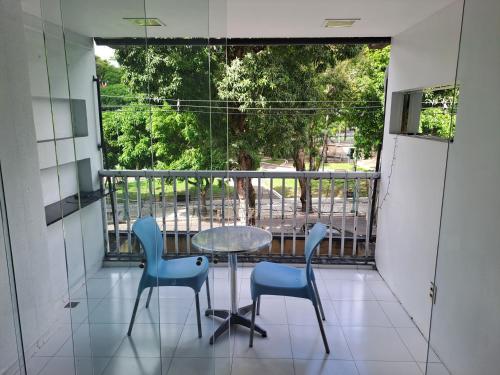 a balcony with a table and chairs and a window at Apto Centro Belém Cop 30 Praça da República in Belém