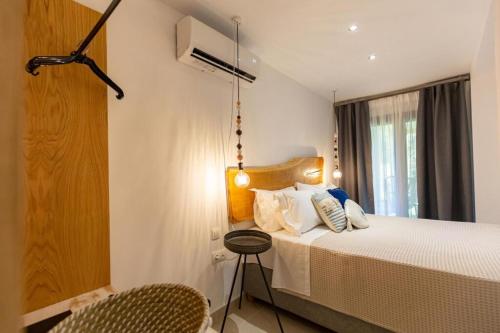 a bedroom with a bed and a chair in it at Blue Sea Suites in Afitos