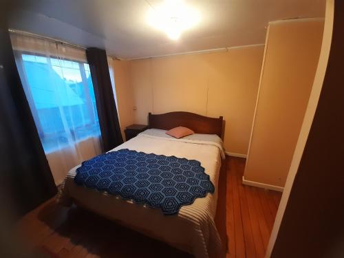 a small bedroom with a bed and a window at cabaña casa amoblada in Puerto Montt