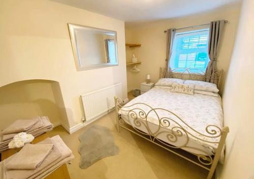 una camera da letto con un letto bianco e una finestra di 43 Heol Maelor- A Homely Cottage in Wrexham, North Wales a Coedpoeth