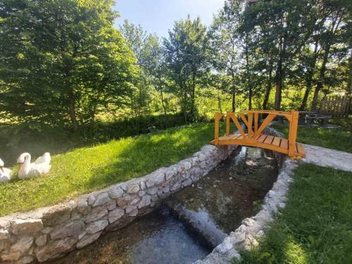 a bridge over a pond with two ducks in the grass at Vikendica, Bazen, Šedrvan, Rafting na Uni, Quad in Bihać