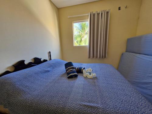 a bed with a pair of socks and a stuffed animal on it at Casa do Pescador - Paripueira in Paripueira