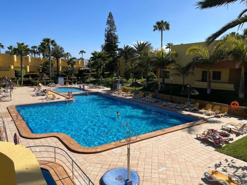 a large swimming pool with people in a resort at Corralejo Atlantic Garden Andrew apartments Pool air conditioning in Corralejo
