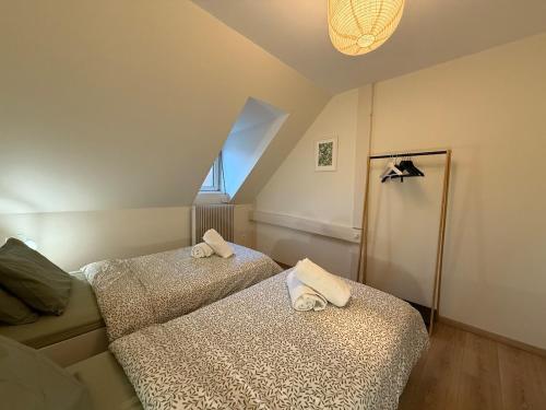 une chambre avec deux lits avec des serviettes dessus dans l'établissement Appartement proche centre ville avec parking, à Colmar
