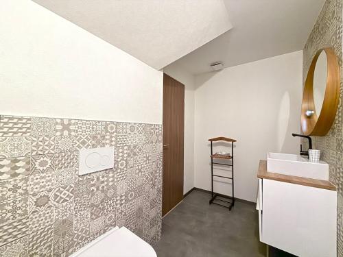 une salle de bain avec toilettes, lavabo et miroir dans l'établissement Appartement proche centre ville avec parking, à Colmar
