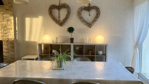 a table with two hearts hanging on a wall at Cozy'Maisonnette 5Chb Brest Guip in Guipavas