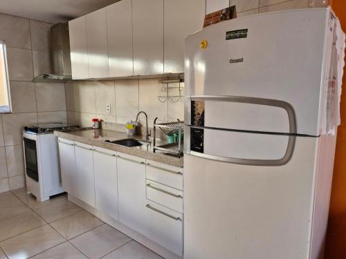 a kitchen with a white refrigerator and a sink at Casa do Pescador - Paripueira in Paripueira