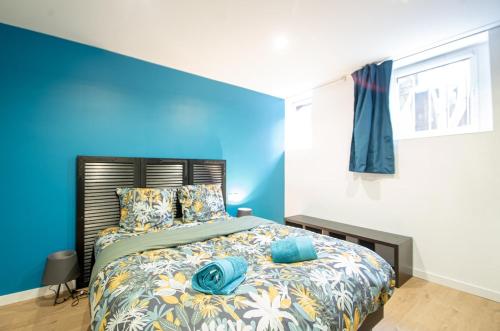 a bedroom with a blue accent wall and a bed at TY AR PARIZ T3 Rennes centre Parc du Thabor in Rennes