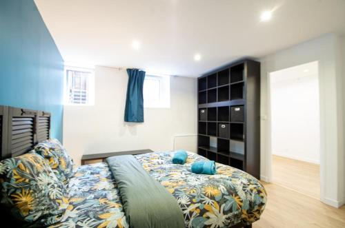 a bedroom with a bed with a blue and white bedspread at TY AR PARIZ T3 Rennes centre Parc du Thabor in Rennes