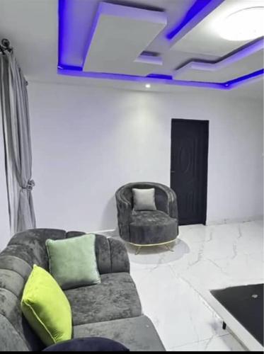 a living room with a couch and two chairs at sunny service apartment in Ogba