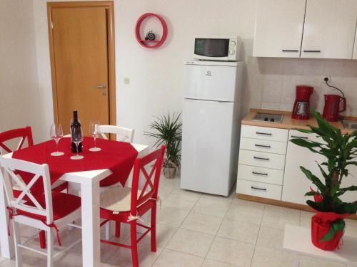 a kitchen with a red table with chairs and a white refrigerator at Villa Jasmin in Bol