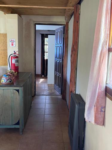 un pasillo de una casa con TV y puerta en Entre Jardines, en El Bolsón