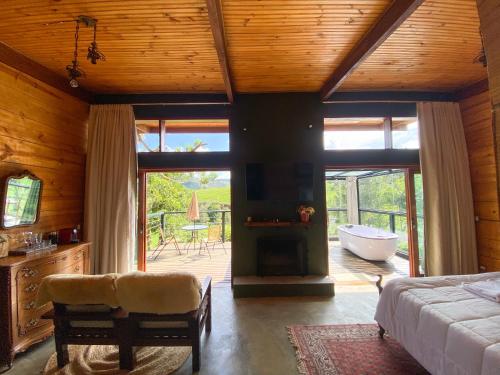 a bedroom with a bed and a tub in a room at Cabana Mantiká in Sapucaí-Mirim