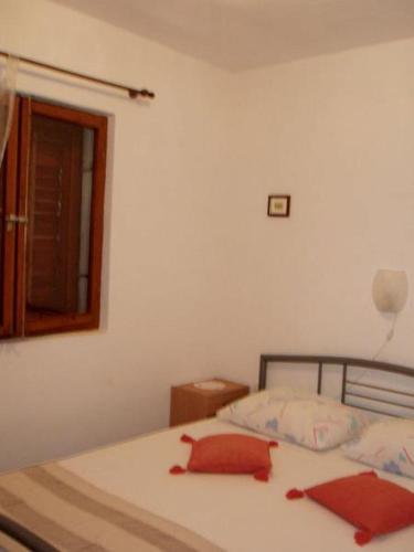 a bedroom with a bed with red sheets and a mirror at Apartments Desa in Prizba