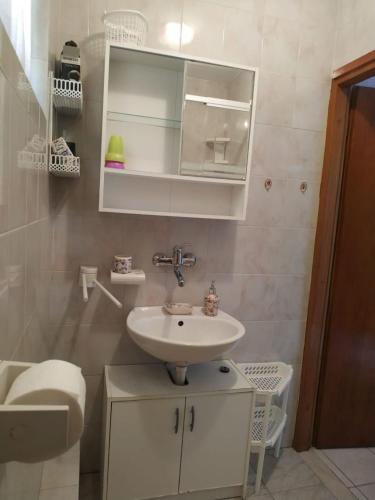 a bathroom with a sink and a toilet at Apartments Desa in Prizba