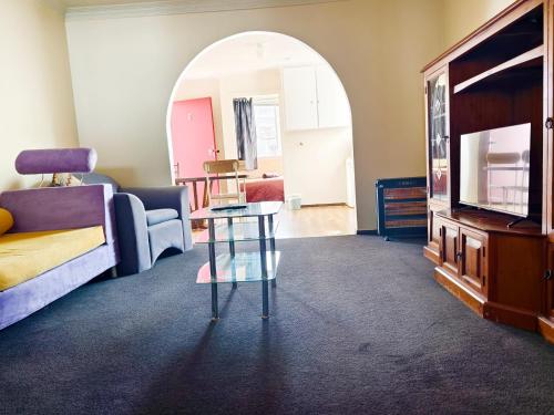 a living room with a couch and a table at Ferry Motel in Christchurch