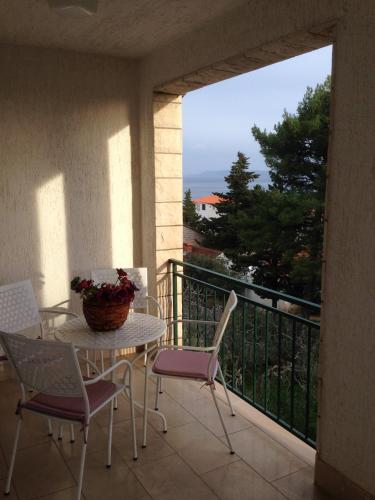 a patio with a table and chairs on a balcony at Villa Jasmin in Bol