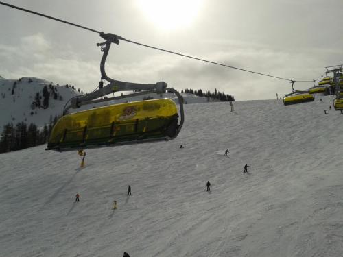 a group of people riding a ski lift in the snow at Appartement Alpenglück in Aich