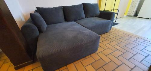 a blue couch sitting in a living room at Cramiland - Appart 01 Ohnenheim in Ohnenheim