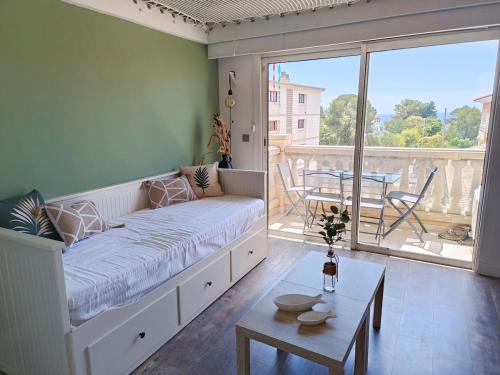 une chambre avec un lit et un balcon avec une table dans l'établissement Charmant appartement à 50m des plages, à Saint-Raphaël