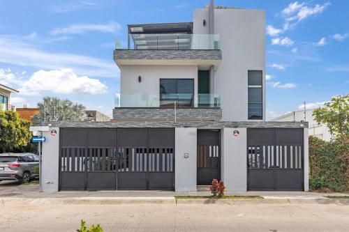 a white house with a black garage at Casa Bella Vacation Home in Puerto Vallarta