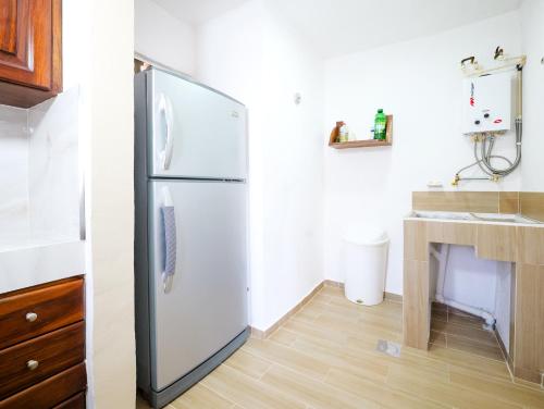 a white refrigerator in a kitchen with a wooden floor at Casa Shiloh-depto 3 hab cerca aero y central camionera in Puerto Vallarta
