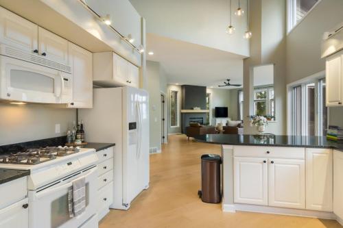 a large kitchen with white cabinets and a living room at Luxury Estate Overlooking Water in Traverse City