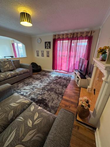 a living room with a couch and a fireplace at Cosy 2bed home near NEC BHX HS2 Business Park in Marston Green