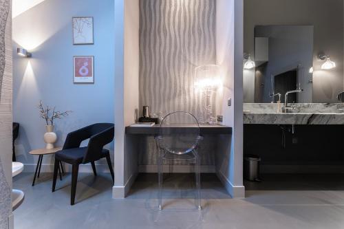 a bathroom with a sink and a table and chairs at Weaving Mill Hotel Suites And Shared Kitchen in Oss