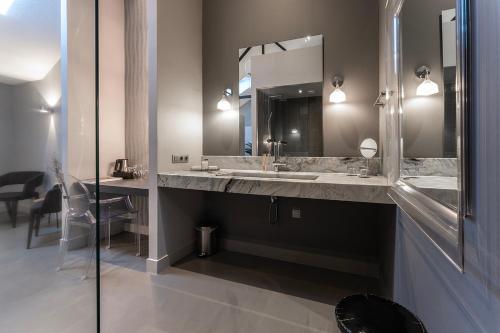 a bathroom with two sinks and a large mirror at Weaving Mill Hotel Suites And Shared Kitchen in Oss