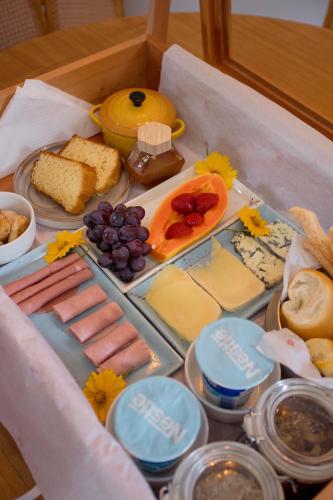 una scatola piena di diversi tipi di formaggio e cibo di Fruto Vermelho Pousada a Pedra Menina