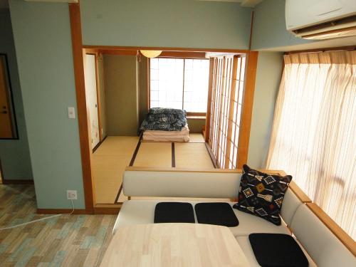 Una pequeña habitación con una cama y una ventana. en 東京の中心地 Okachimachi Staypia, en Tokio