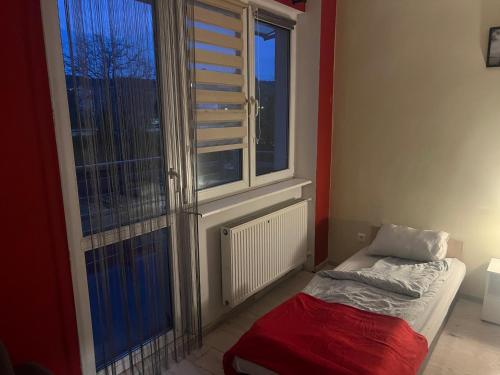 a room with a window and a bed in front of it at Kwatery pracownicze Rumia in Rumia