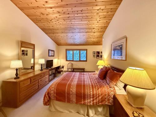 Un dormitorio con una cama y un techo de madera. en Hidden Village 724, en Big Sky