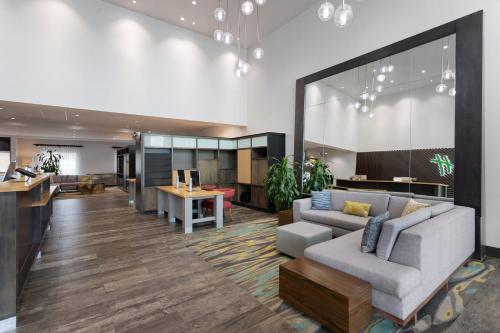 an office lobby with a couch and a bar at Holiday Inn & Suites - Savannah Airport - Pooler by IHG in Savannah
