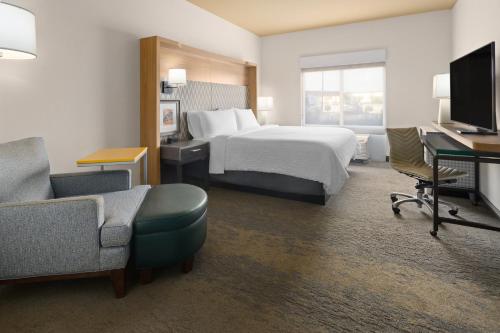a hotel room with a bed and a desk and chair at Holiday Inn & Suites - Savannah Airport - Pooler by IHG in Savannah