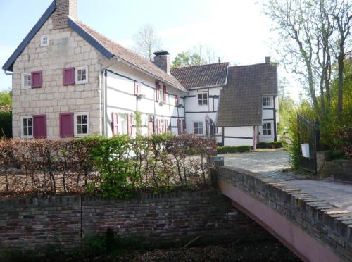a white house with red shutters on a bridge at Hotel Brull in Mechelen